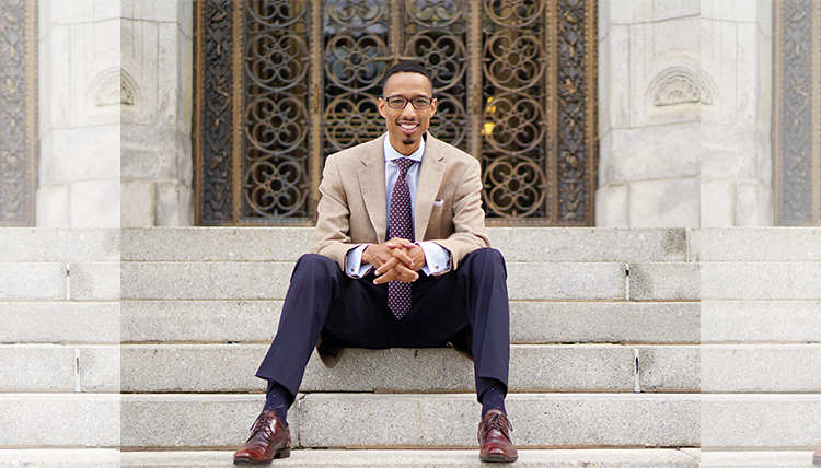 black professor in suit on steps
