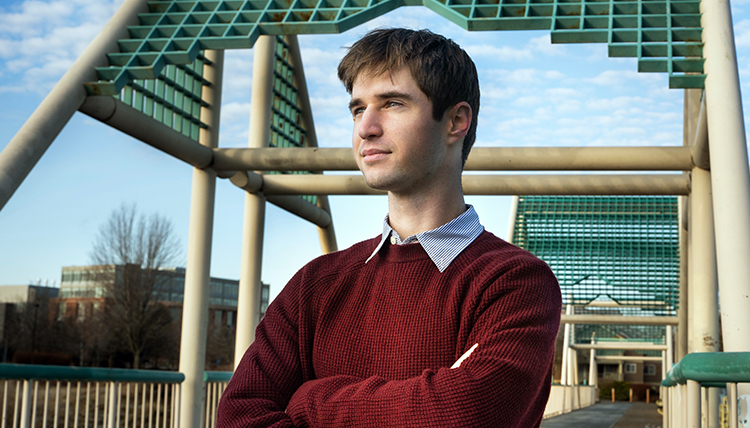 young man in sweater on bridge