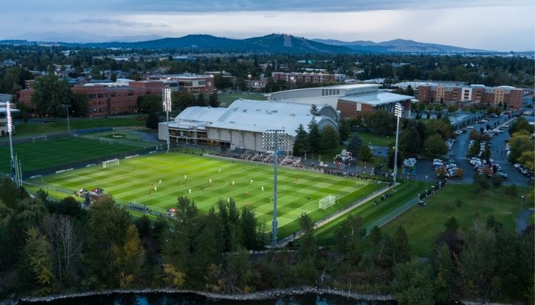 Drone shot of the Martin Centre, which contains Rudolf Fitness, and Luger Field, the soccer field. People can be seen playing on the field/.