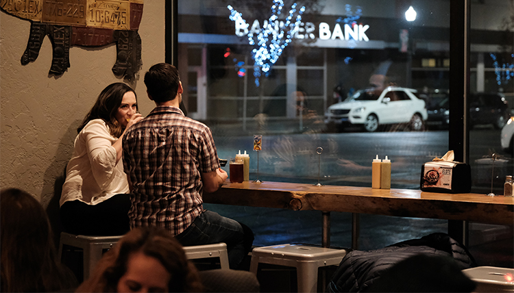 A man and a woman share drinks and a snack at a restaurant in downtown Spokane. 