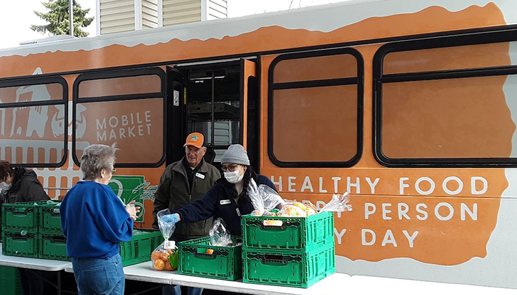 April Lopez, Gonzaga alumna and Americorps member, assists at food distribution.