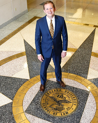 Jacob Rooksby standing on the GU Law School seal