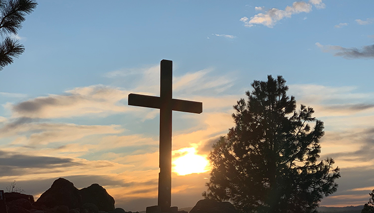 a cross backlit with the setting sun