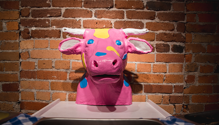 sculpture of a pink cow's head with patches of blue