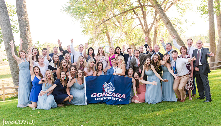 Large group poses in behind Gonzaga flag
