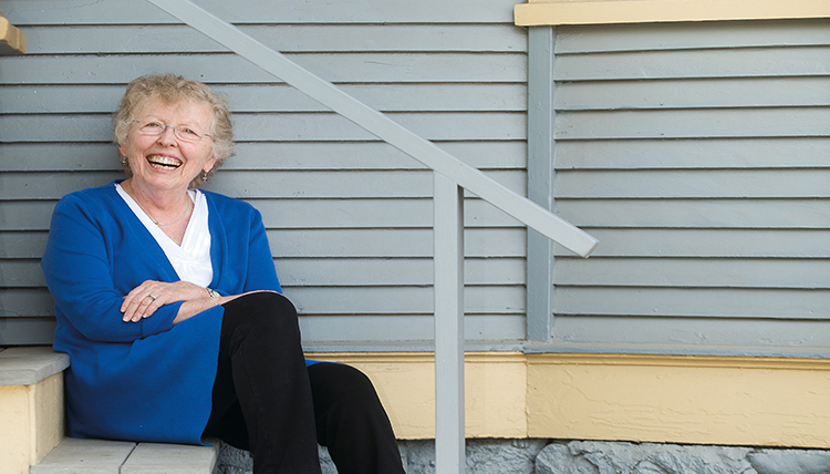 woman sitting on gray steps outside house