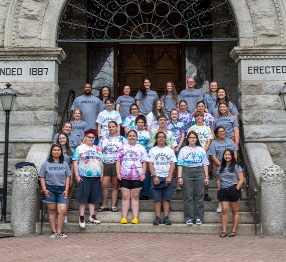 Group of staff, 51Թs, and high school youth posing on the steps of College hall. 