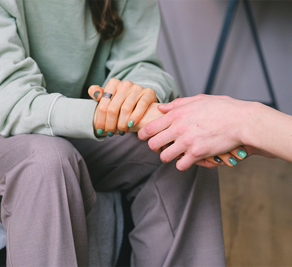 Two people holding hands conversing