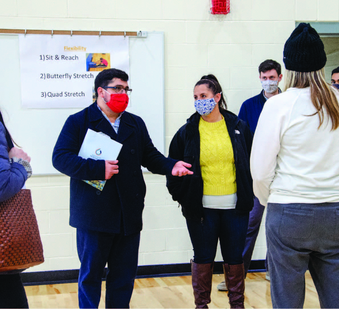 Faculty and staff in discussion inside the Shaw middle school gym. 