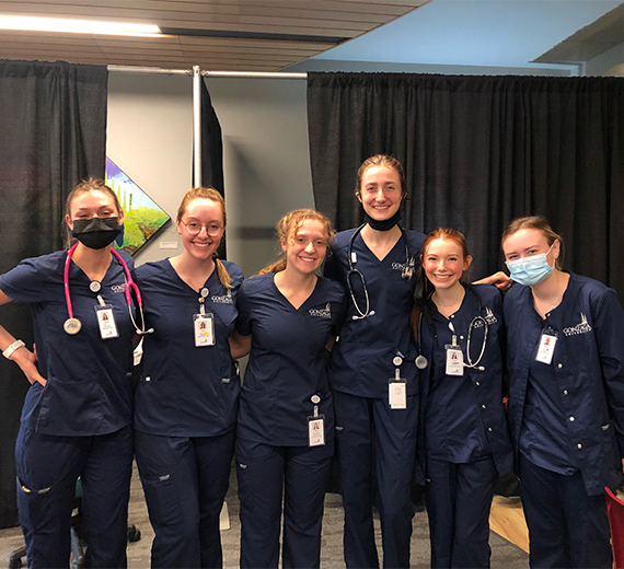 6 nursing students wearing scrubs waiting ready for patients 