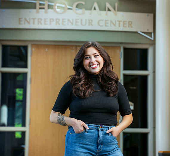 Female student standing in front of Hogan Entrepreneur Center 