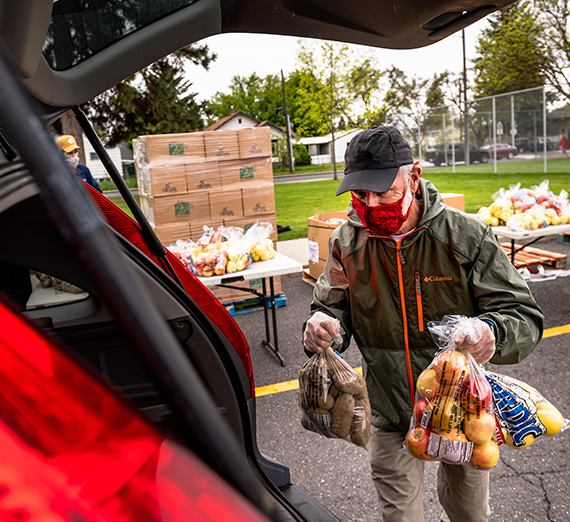 Volunteer loads food into vehicle.