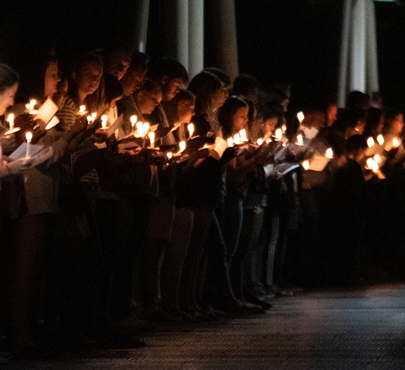 people standing together with candles