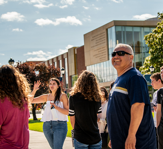 Student giving campus tour to a group in front of Hemmingson Center.