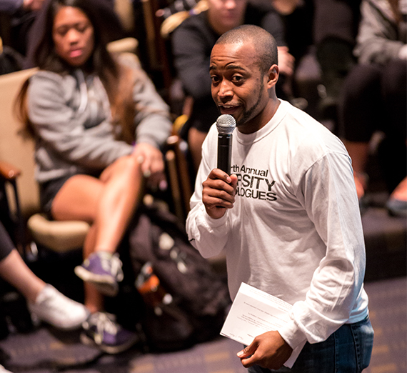 A student speaks to a crowd using a microphone.