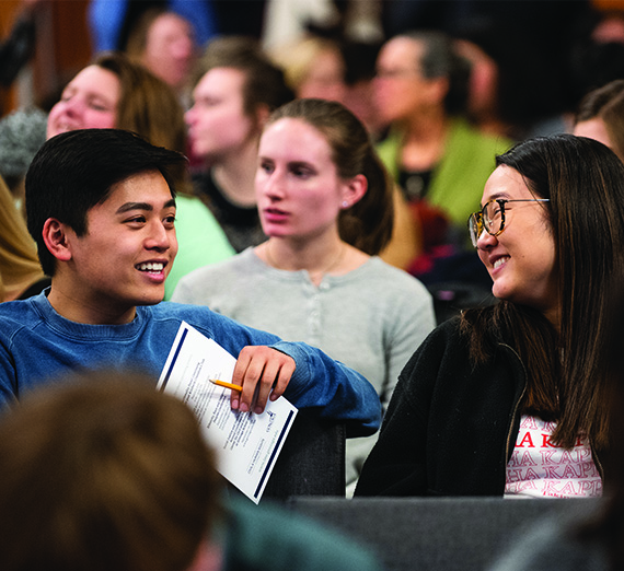 A male and female student chat before a presentation.