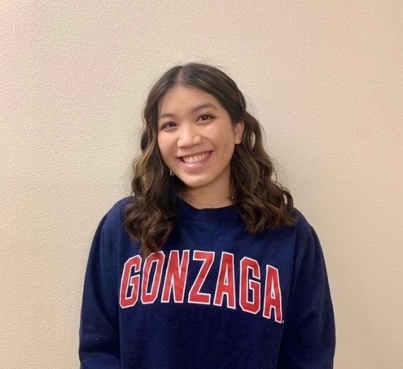 A photo of Annie French. She is smiling wearing a dark blue long sleeve shirt with GONZAGA written in red.