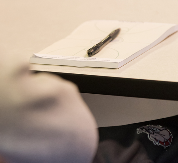 A notebook and a pen sit on a desk.