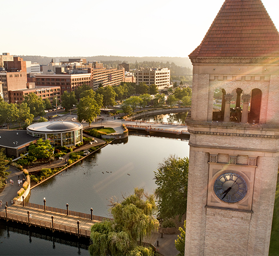 Drone image of downtown Spokane, featuring the clock tower, river, and Riverfront Park. 
