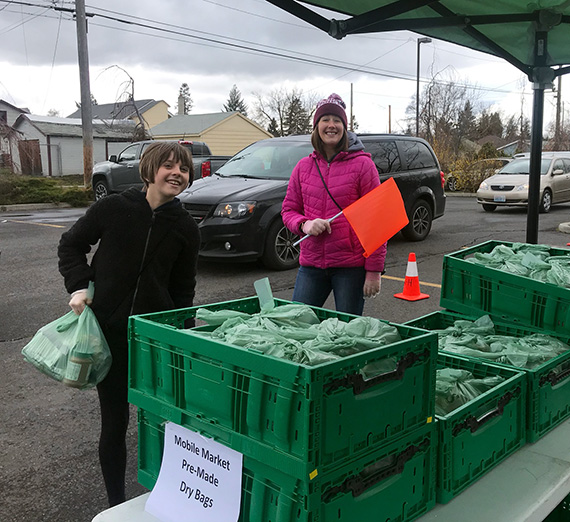 ZoNE Project Director Amber Waldref and volunteers work at a food distribution site in Northeast Spokane 