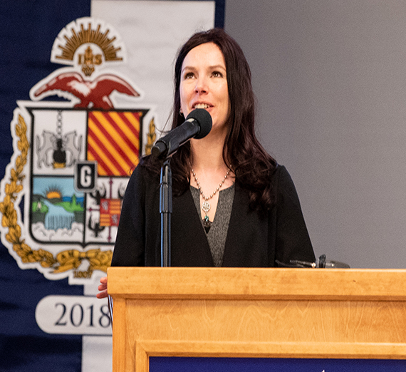 man with white hair at podium