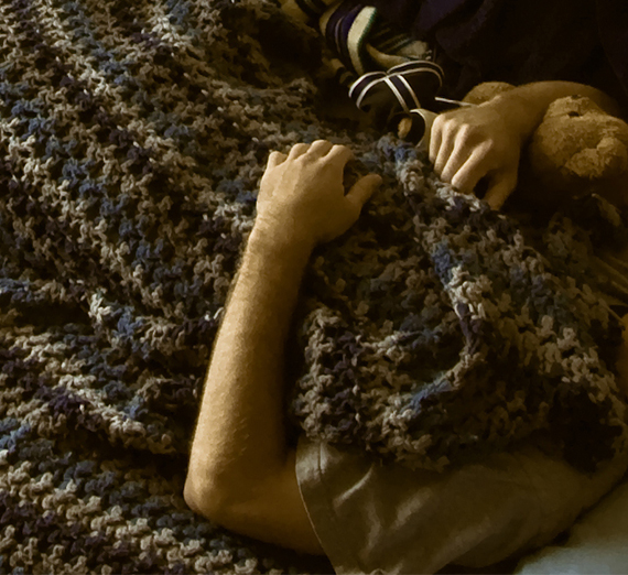 a male student with blanket and teddy bear