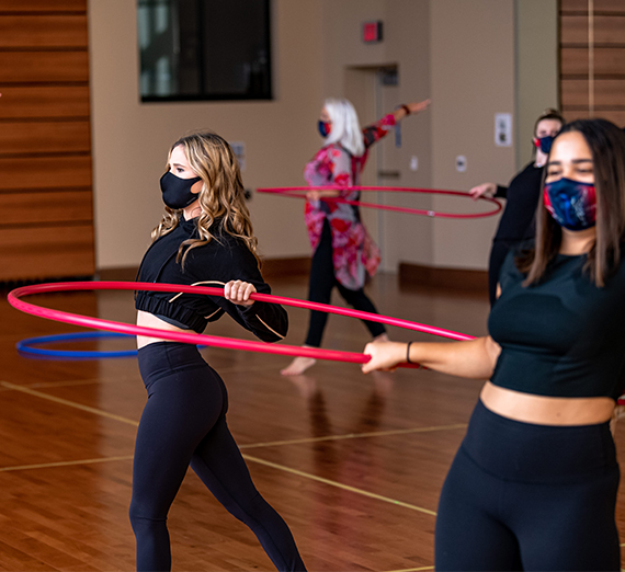 students dance with hula hoops to maintain distance