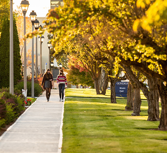 two people masked walked on campus in fall