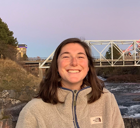 Oakley Wurzweiler smiling in front of a bridge and river.