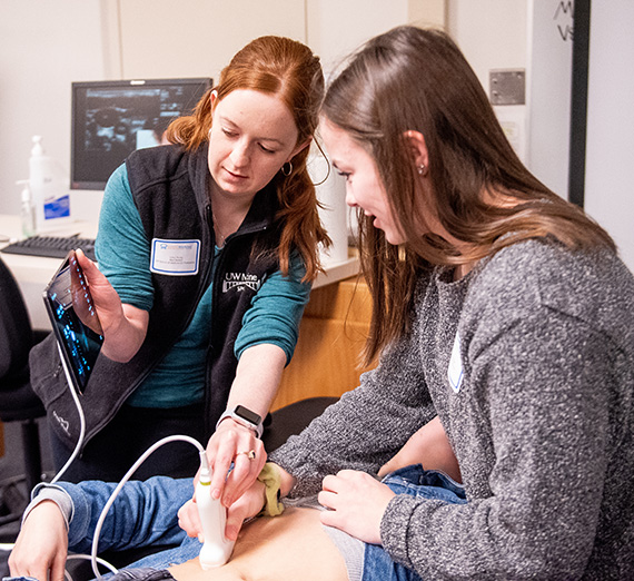Students using medical devices on patient 