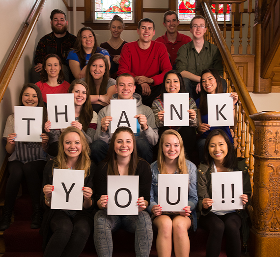 group of students on steps with letters spelling thank you