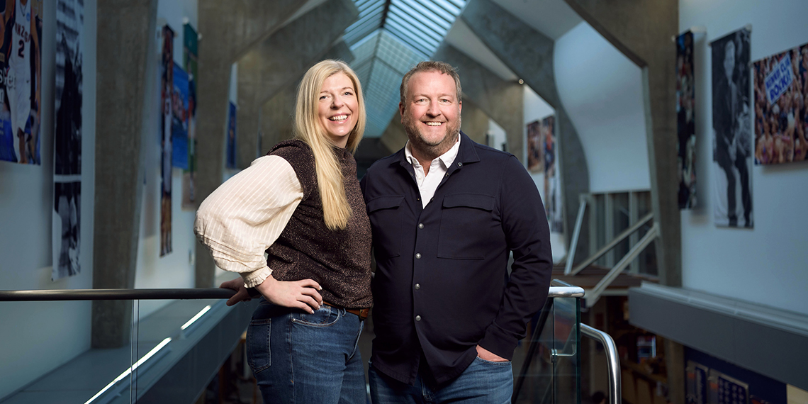 Katie and Ryan Harnetiaux smile as they stand in the Gonzaga Hall of Honor