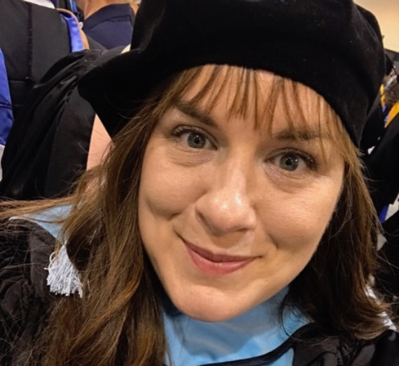 Mary Stover poses for photo in GU cap and gown 