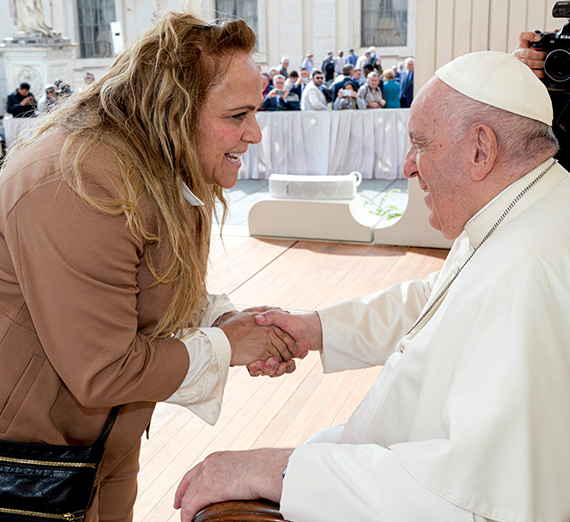 Christy Larsen shakes hands with Pope Francis.