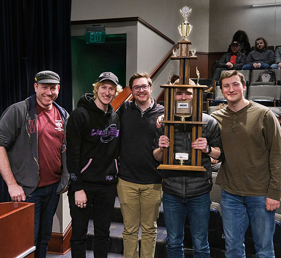 Four students holding large trophy