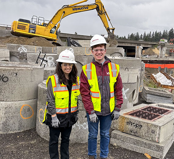 Two people in hard hats on a construction site