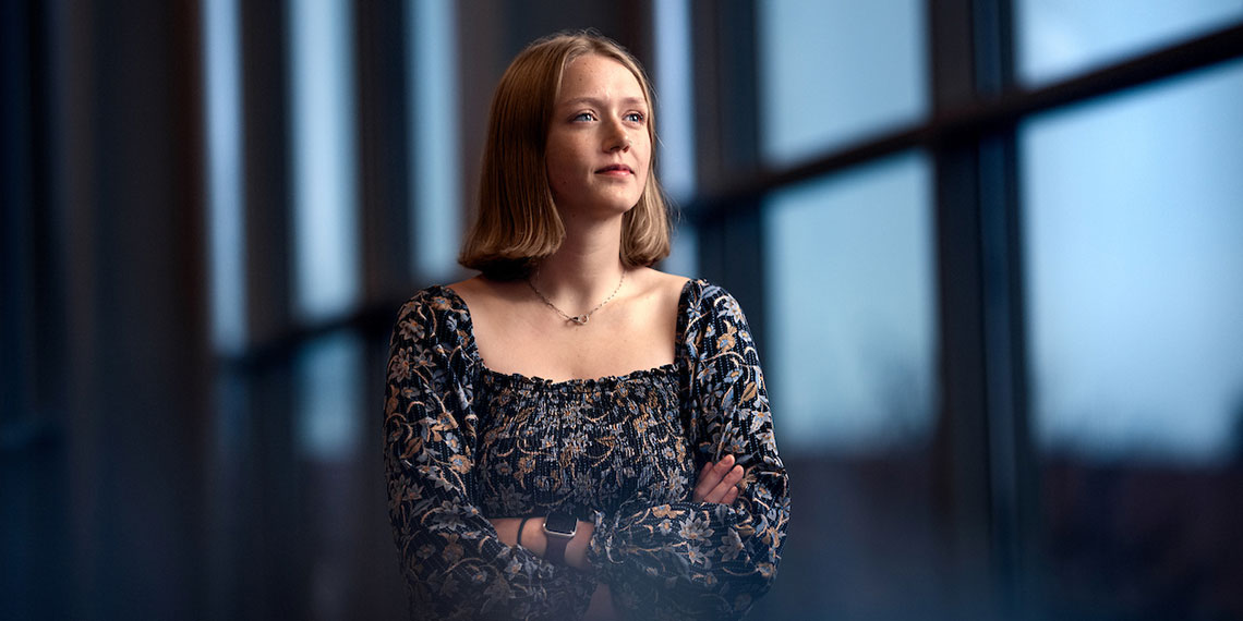 Senior Maddie Sontag stands in front of windows