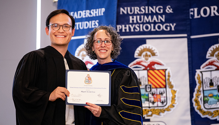 student and dean pose with award