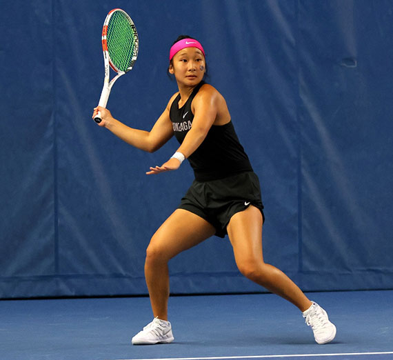 Student Kianna Oda prepares to hit a tennis ball