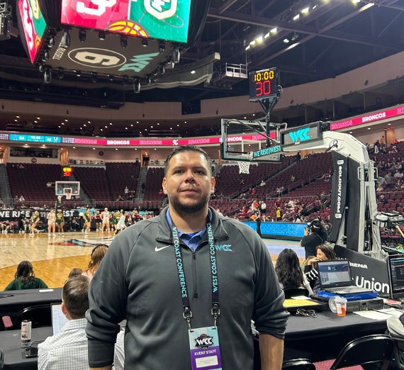 Chris Navarro poses in front of WCC basketball court