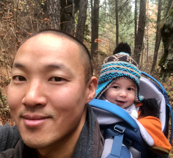 Ben Chu on a hike with a baby on his back.