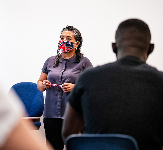 masked faculty member teaching students