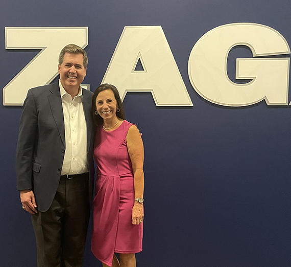 Julia Bjordahl standing with Thayne McCullouh in front of a Gonzaga sign