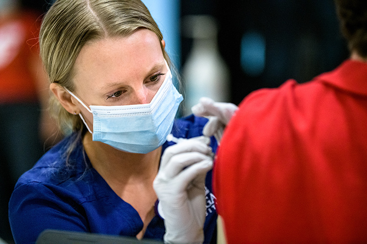 A female nursing student administers a vaccine