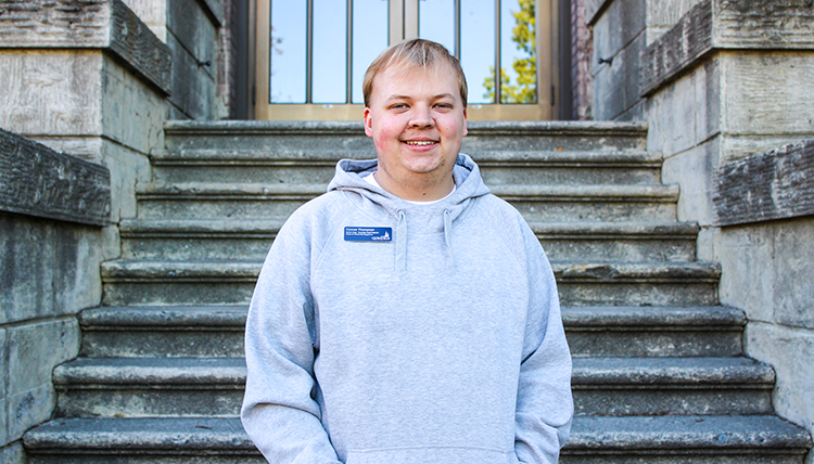 A man with blond hair wearing a gray sweatshirt