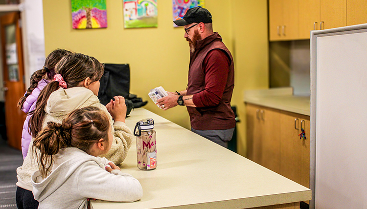 A man teaching kids in a kitchen.