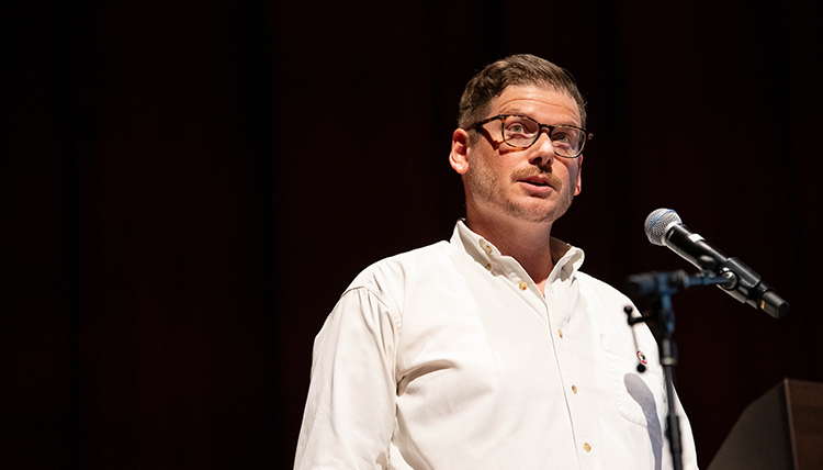 A man speaks at a microphone