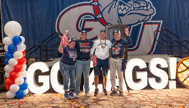 Gonzaga fans in front of a "Go Zags" sign.