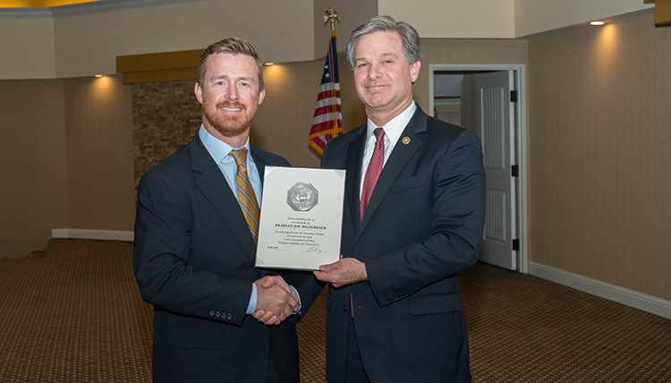 Two men shake hands.