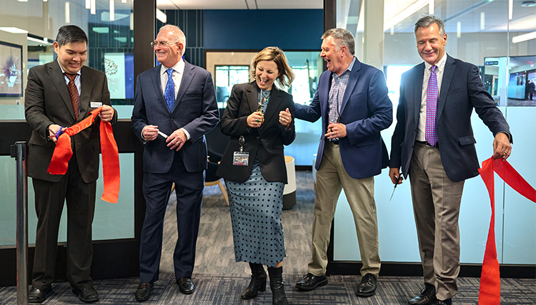 People cut a ribbon in front of a new building.